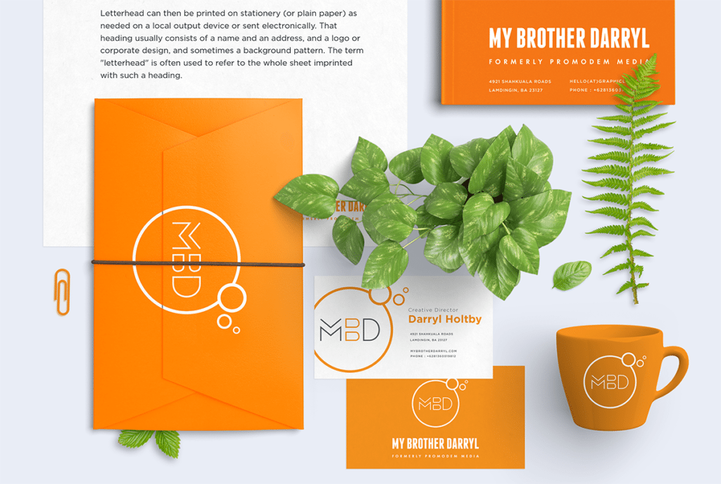 My Brother Darryl logo on orange folders, and an orange mug with green plants on a white tabletop.