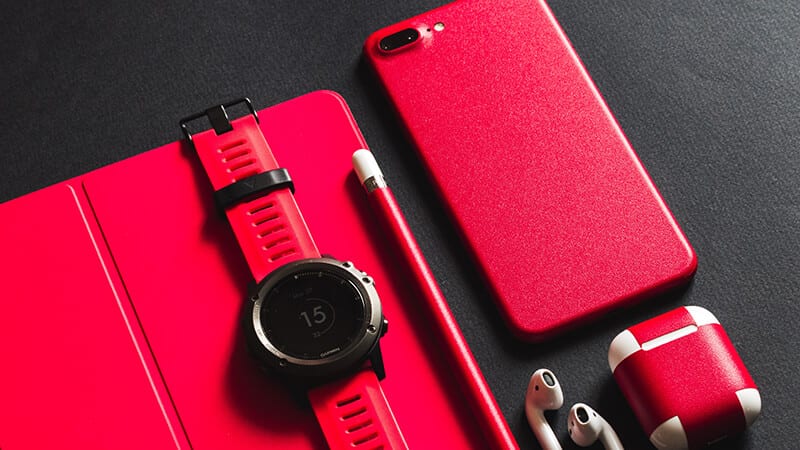 Image of Red book, red smart watch, red smart phone, red case for earphones
