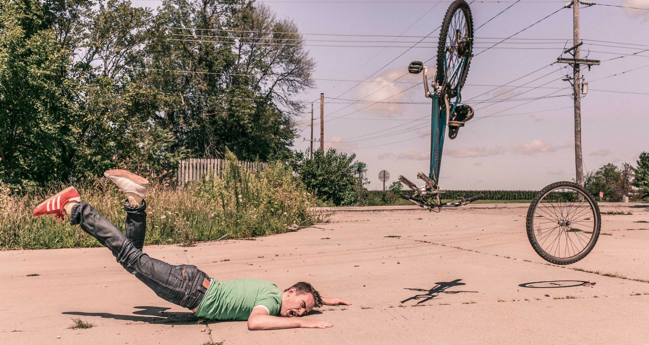 Man falling off of a bicycle onto the pavement