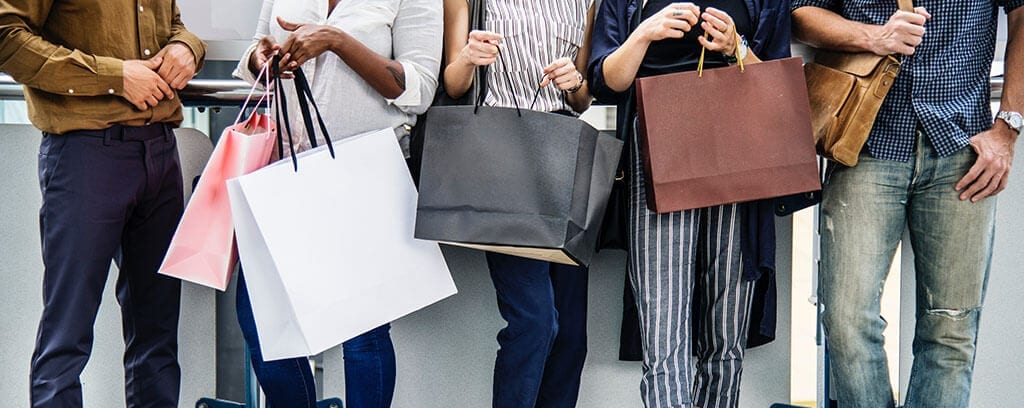 5 people holding large shopping bags of all different colors
