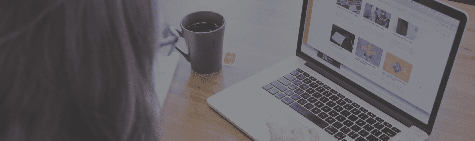 Faded image of person with tea sitting at a table with laptop