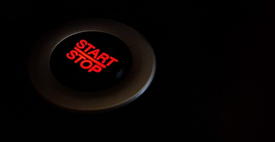 Black image with a black button, silver edging, red glowing letters "Start | Stop"