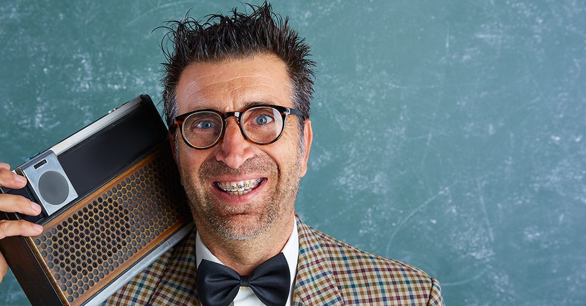 Nerdy looking man with bow tie, heavy glasses, tweed jacket, with old 1960's radio sitting on his shoulder.