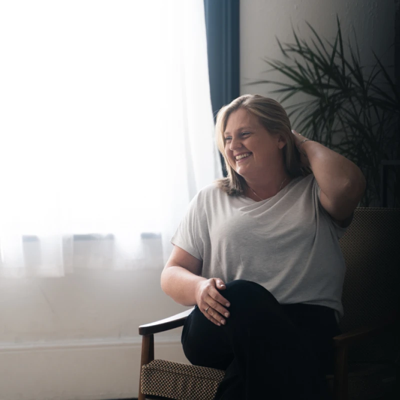 Mirjana pushing back hair sitting by window