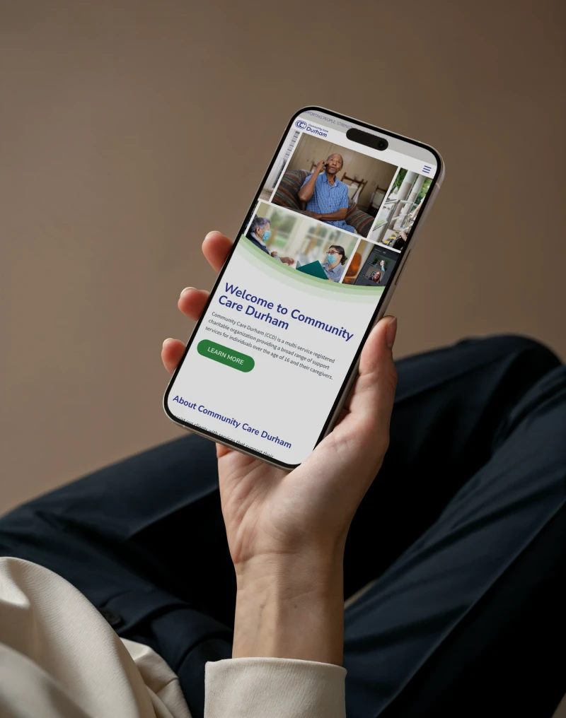 Female hand holding a mobile phone with community Care Durham on screen. Digital Website Development by My Brother Darryl