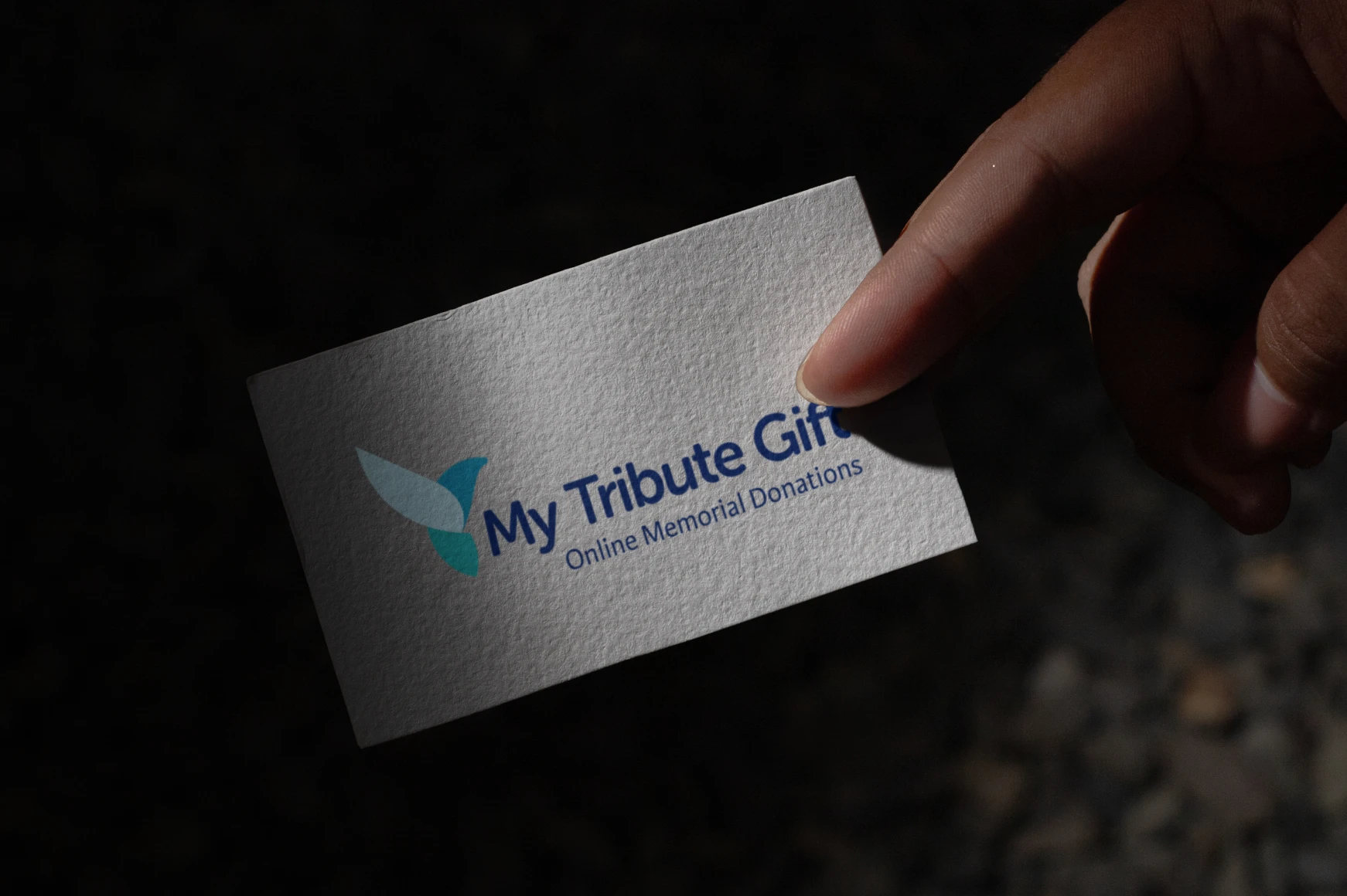 My Tribute Gift Business card being held between fingers by a female hand