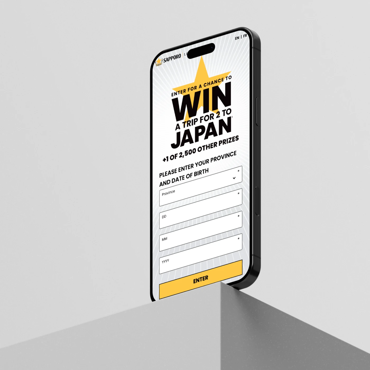iPhone standing vertically on a table top corner with mobile version of Contest Website on screen. Digital Development by MBD